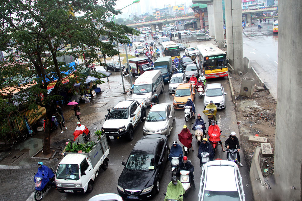 Vật vã chôn chân hít khói ô tô trong mưa rét Hà Nội